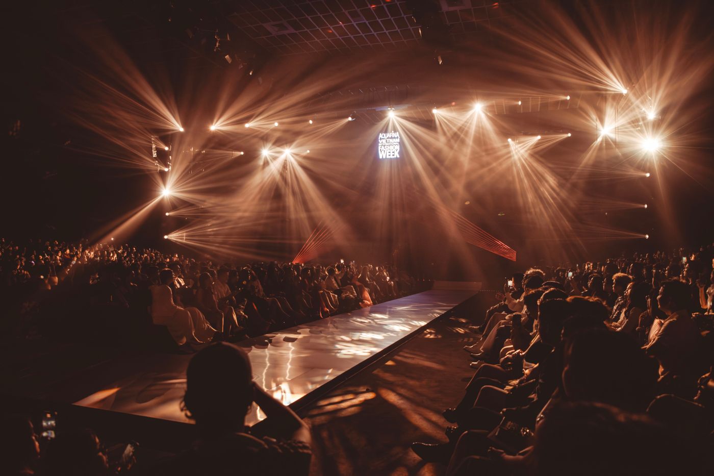 A fashion show runway with audience and stage lights